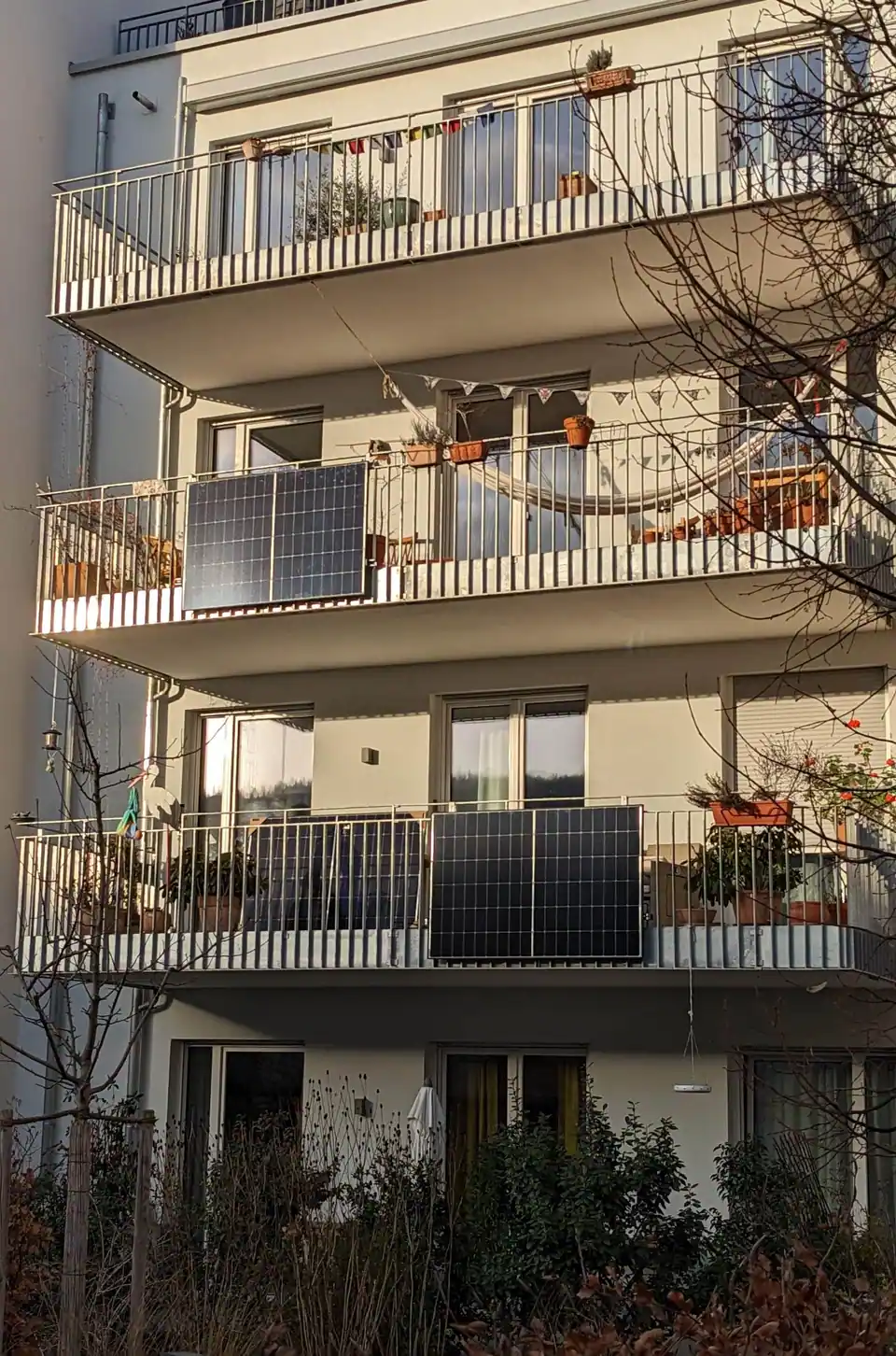 Solar panels hung on the railings of two apartment balconies, one above the other